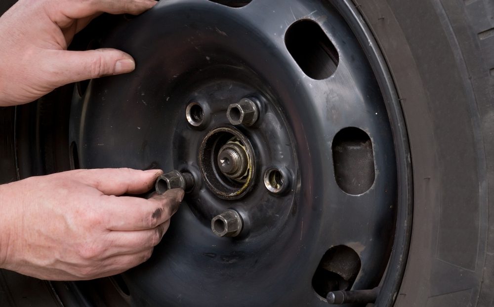 Auto Mechaniker Schrauben oder abschrauben Rad angehobene